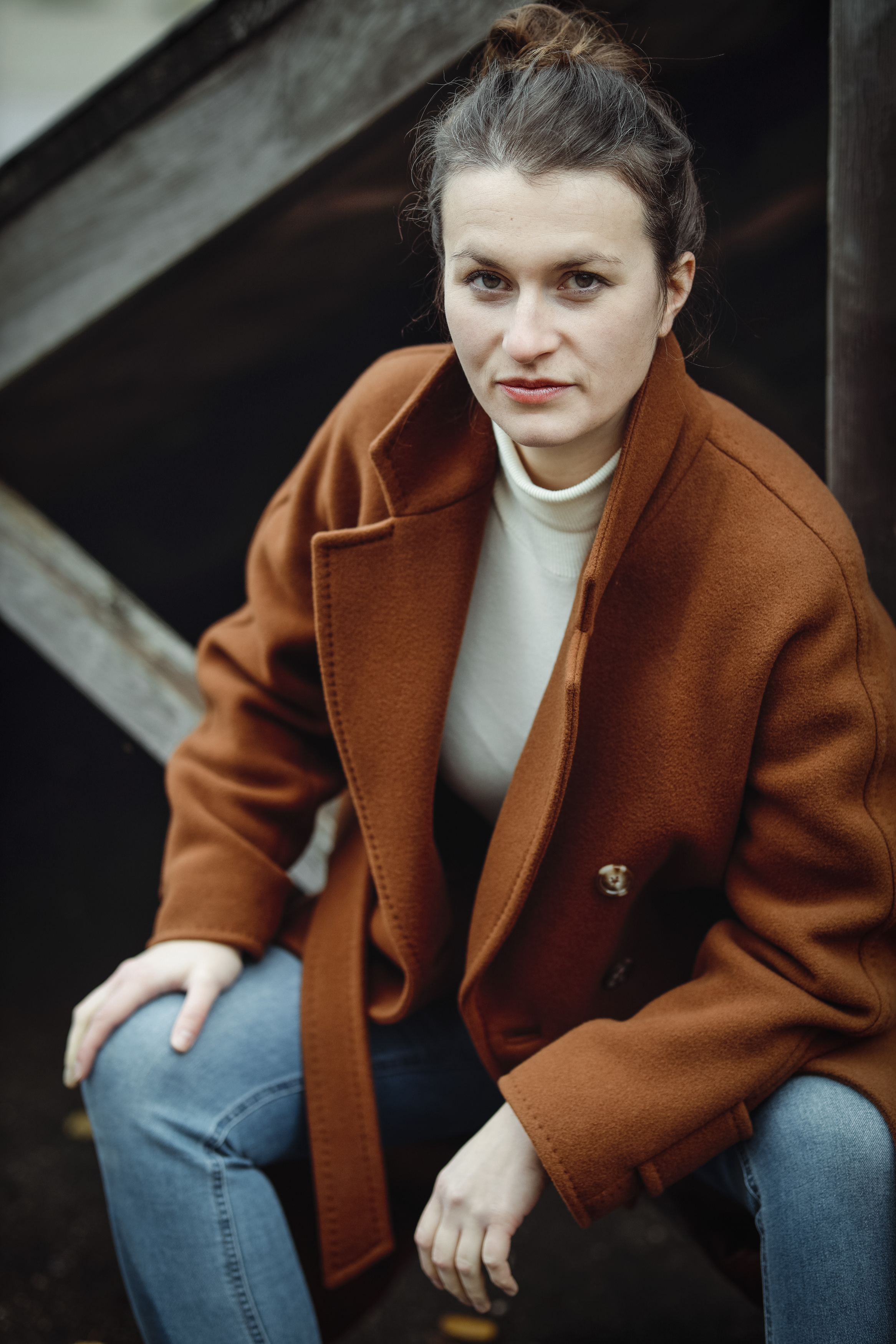 With brown coat, sittig and leaning